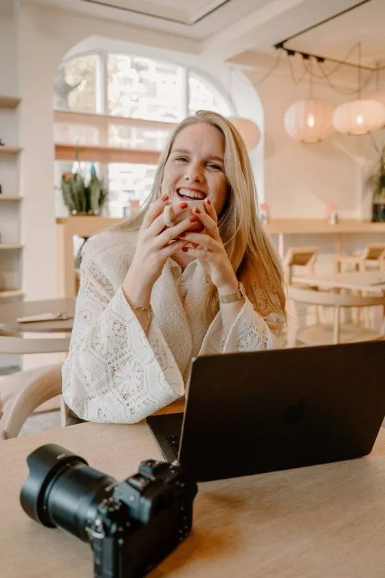 Laura Lokerse van laulokersefotografie, achter haar laptop met een camera op tafel